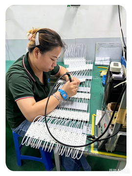 Technician performing wire soldering on LED strip connectors